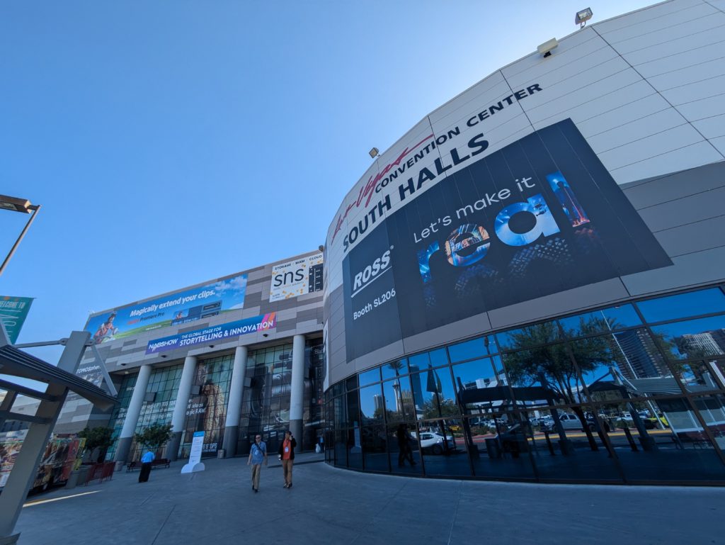 A wide angle view looking up at the South Hall of the Las Vegas Convention Center, showing hoardings advertising exhibitors at the 2025 NAB Show.
