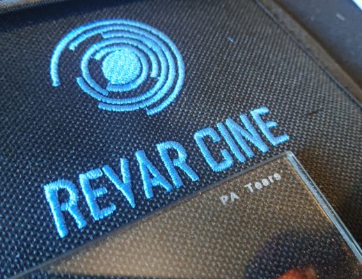 Closeup of a camera filter marked PA Tears lying on a Revar Cine filter pouch. Reflective flakes are visible in the structure of the filter.