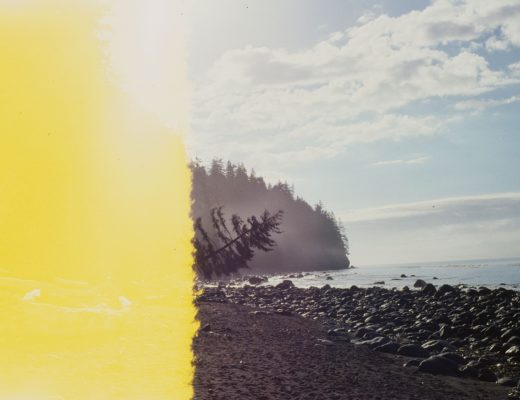 Photo of a rocky, alpine shoreline taken at the beginning of a roll of film, where half the frame has been erased by exposure to light.