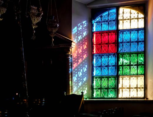 Stained glass window including red, green, blue and uncoloured panes.