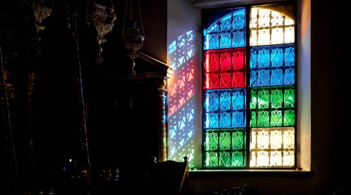 Stained glass window including red, green, blue and uncoloured panes.