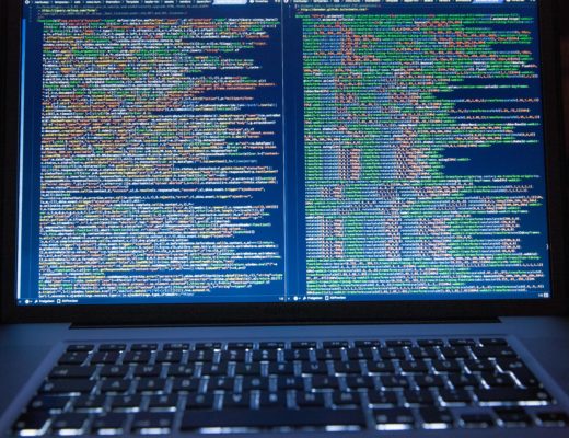 A laptop displaying closely packed lines of computer code.