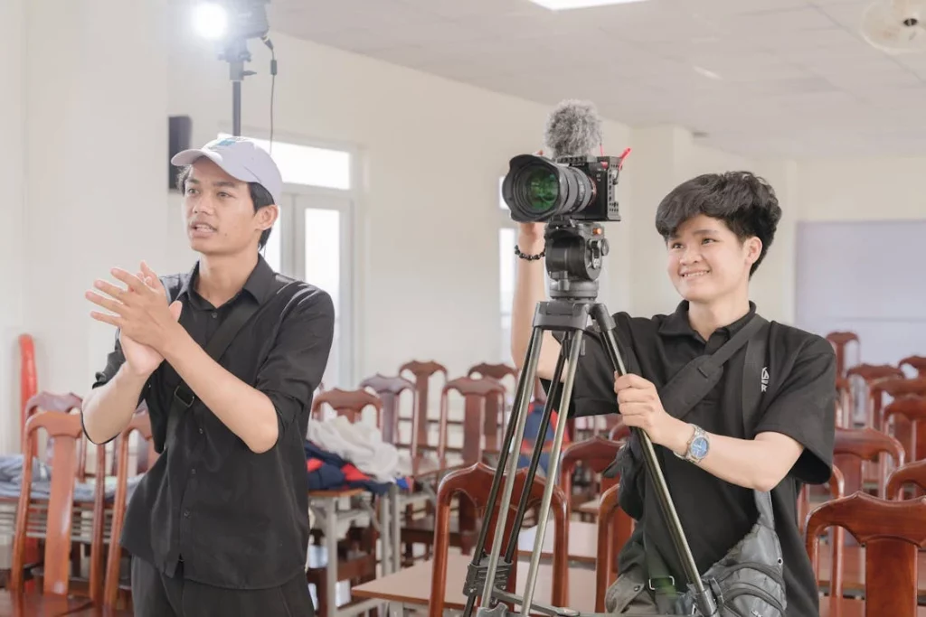Two college-age people with a low-cost mirrorless camera on a lightweight tripod.