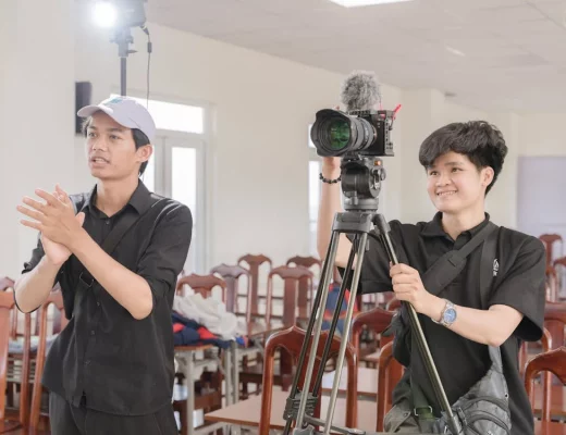 Two college-age people with a low-cost mirrorless camera on a lightweight tripod.
