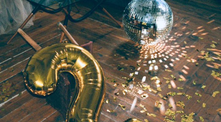 The aftermath of a party, with glitter on the floor and empty wine glasses on the coffee table.