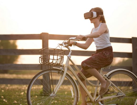 A woman on a bicycle wearing a virtual reality headset.