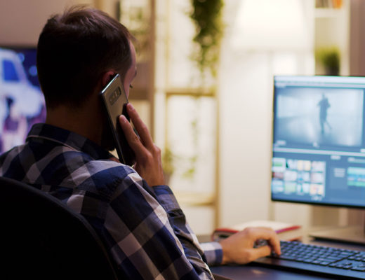 content-creator-talking-on-the-phone-while-working-on-a-multimedia-project