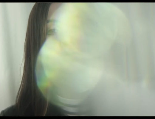 A young woman's face is almost completely obscured by a bright optical effect